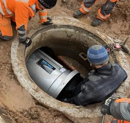 installation-af-kort-wastop-ventil-med-dykker-i-smalt-kammer-da Dykker forbereder installation af WaStop DN700 for at forhindre tilbageløb i Münster industriområde