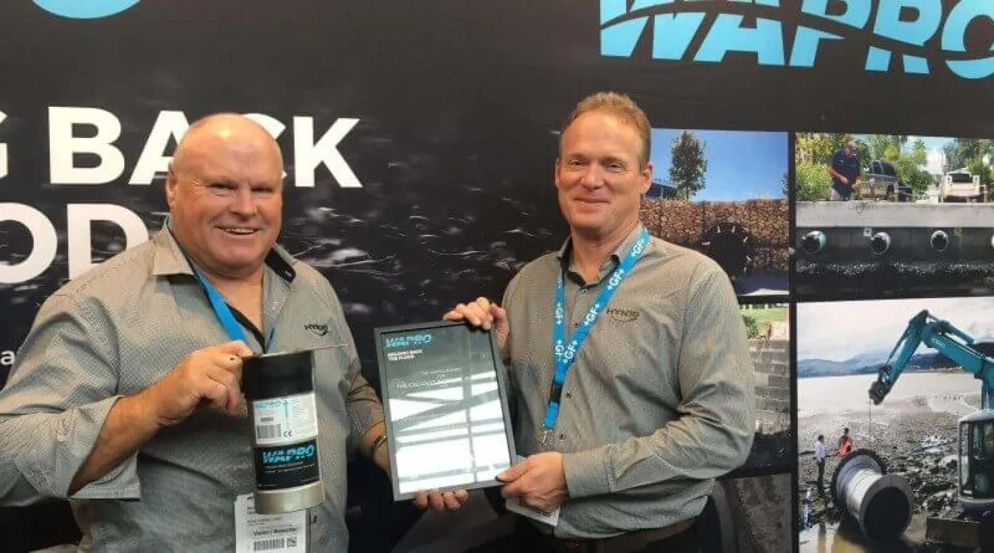 Two men on the Wapro stand holding a framed certificate and a WaStop valve at Wapro’s bi-annual awards ceremony Two men on the Wapro stand holding a framed certificate and a WaStop valve at Wapro's bi-annual awards ceremony