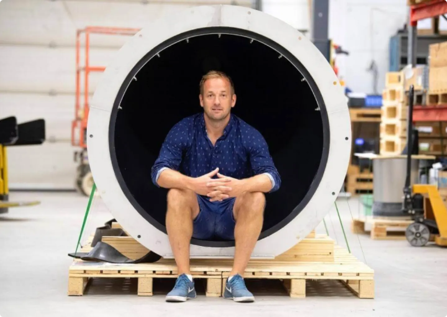 Peter Olsson, Nordic Sales Manager at Wapro, sitting inside a large white valve on a pallet in the warehouse
