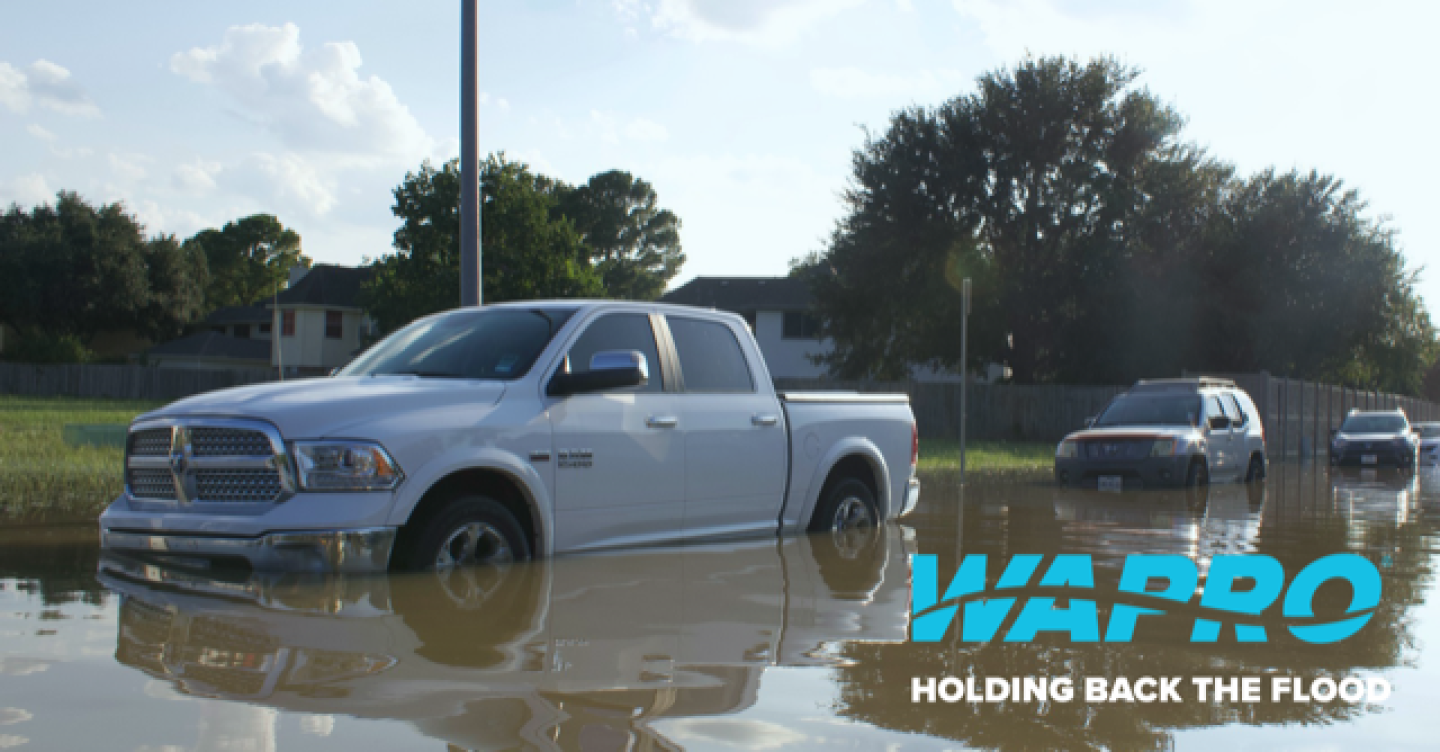 Weißer Pick-up auf überfluteter Straße mit Wapro-Logo und Slogan Holding back the flood, Einladung zum digitalen Event Weißer Pick-up auf überfluteter Straße mit Wapro-Logo und Slogan Holding back the flood, Einladung zum digitalen Event